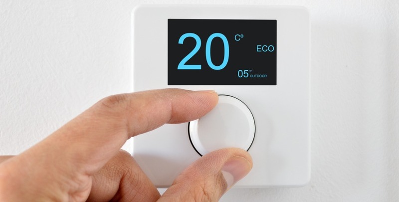 A homeowner adjusts the air conditioner thermostat